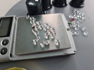 clear gemstones being weighed on a precision scale