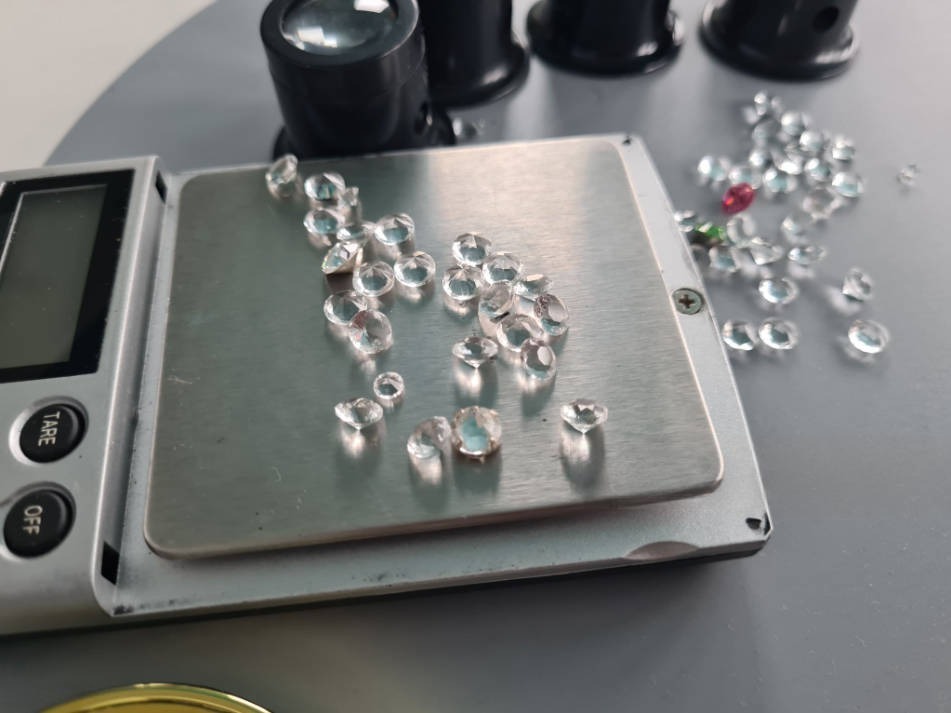 clear gemstones being weighed on a precision scale
