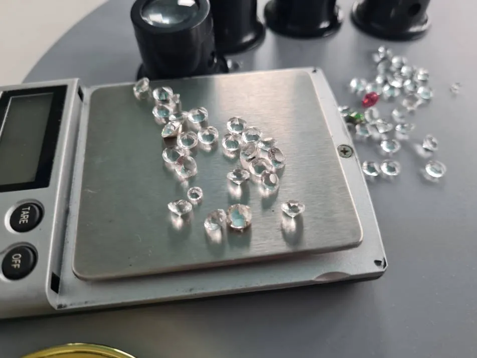 Clear gemstones being weighed on a precision scale